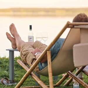 Mann sitzt am See entspannt